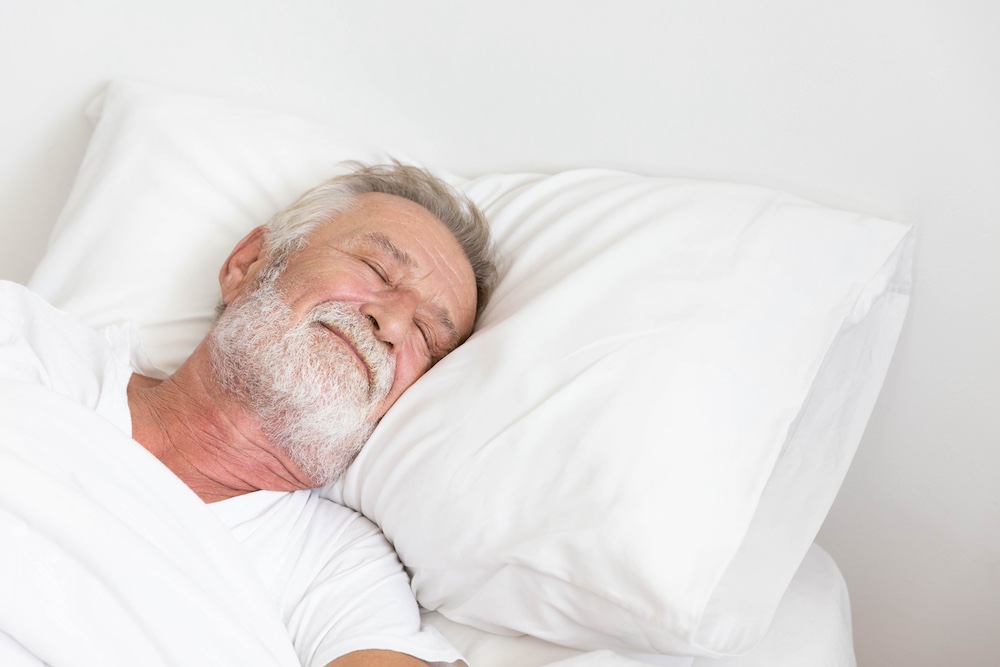 A relaxed senior man resting in bed