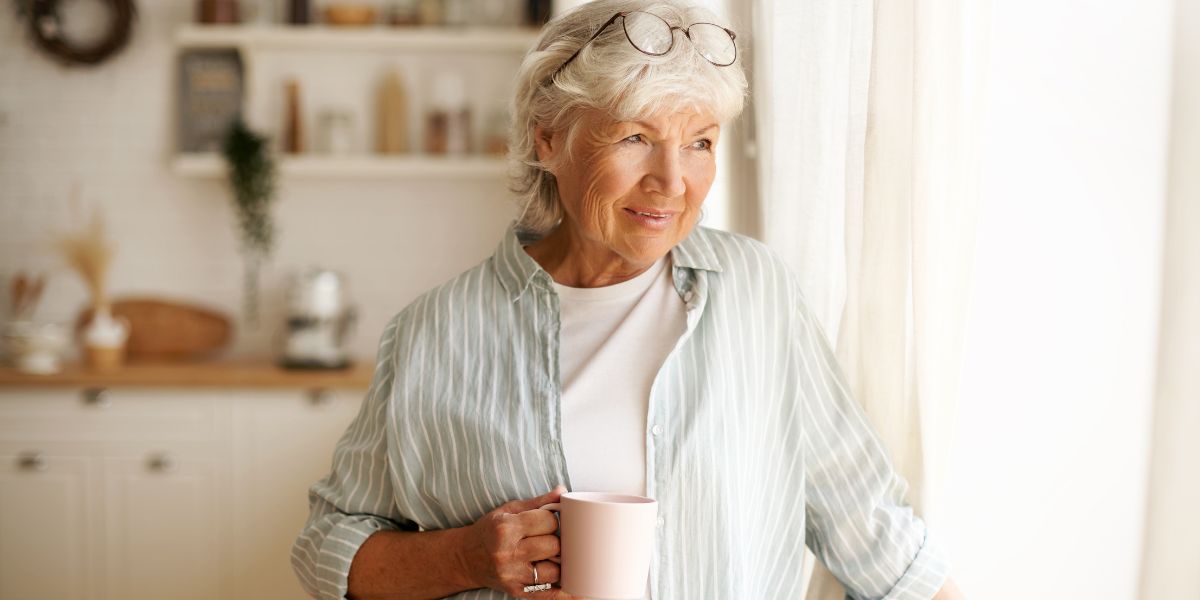A woman holding a mug of tea at the senior care in Fresno
